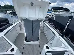 Slide: The Image of 2024 Yamaha Boats 252 FSH Sport interior with open storage compartment, docked at marina. - 8