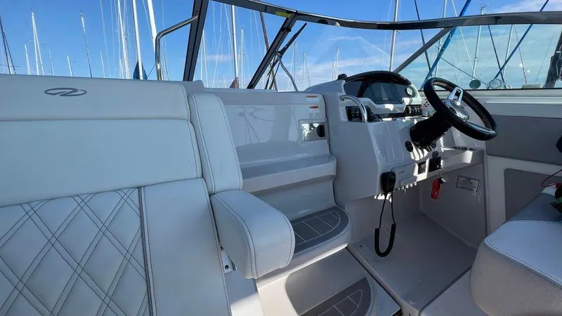 Slide: The Image of 2021 Regal 28 Express boat interior with white seating and steering wheel. - 2