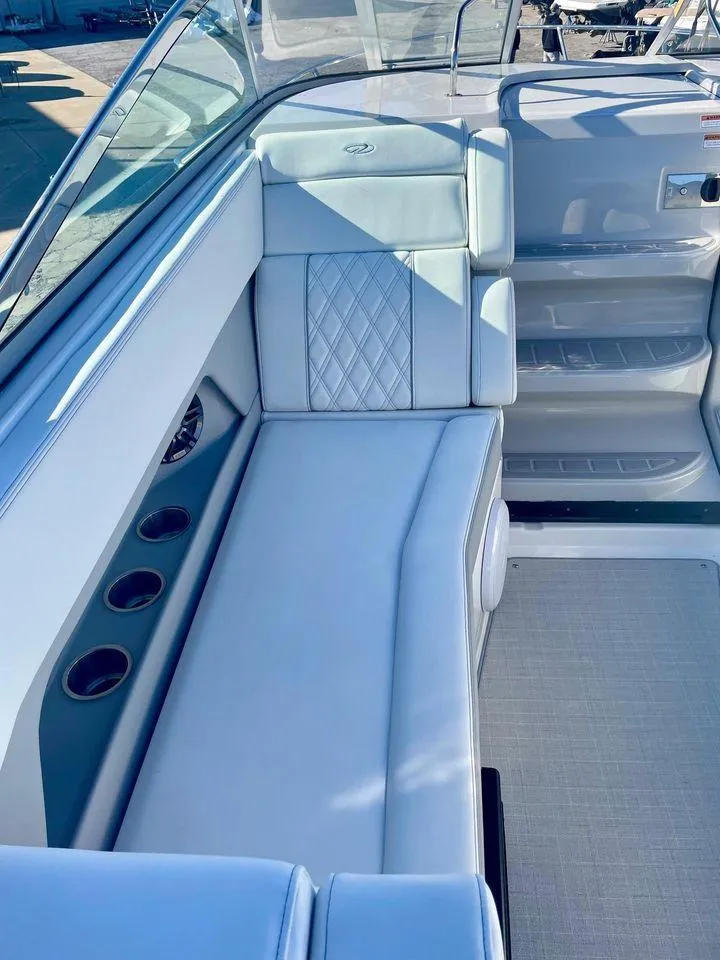 Slide: The Image of 2021 Regal 28 Express boat interior with white seating and cup holders. - 4