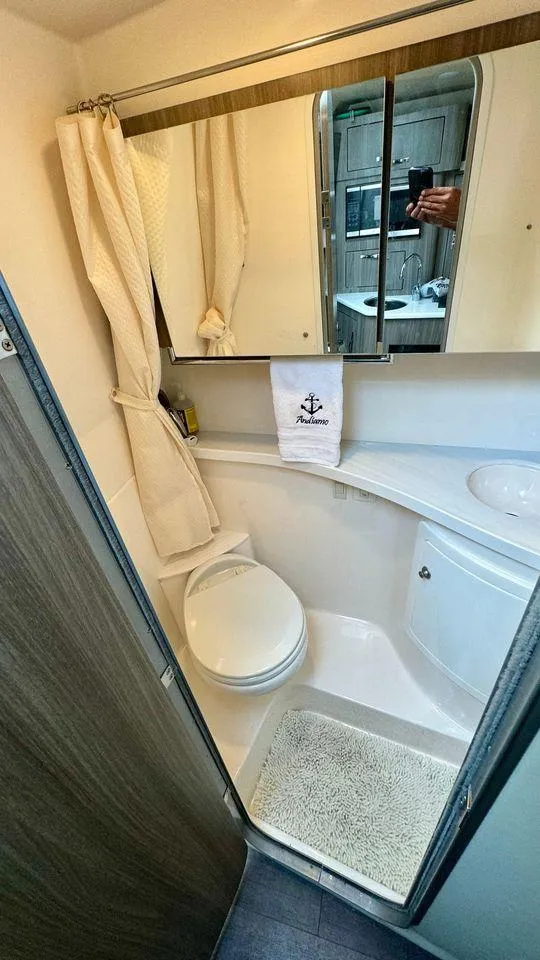 Slide: The Image of 2021 Regal 28 Express bathroom with shower, mirror, and nautical-themed decor. - 7