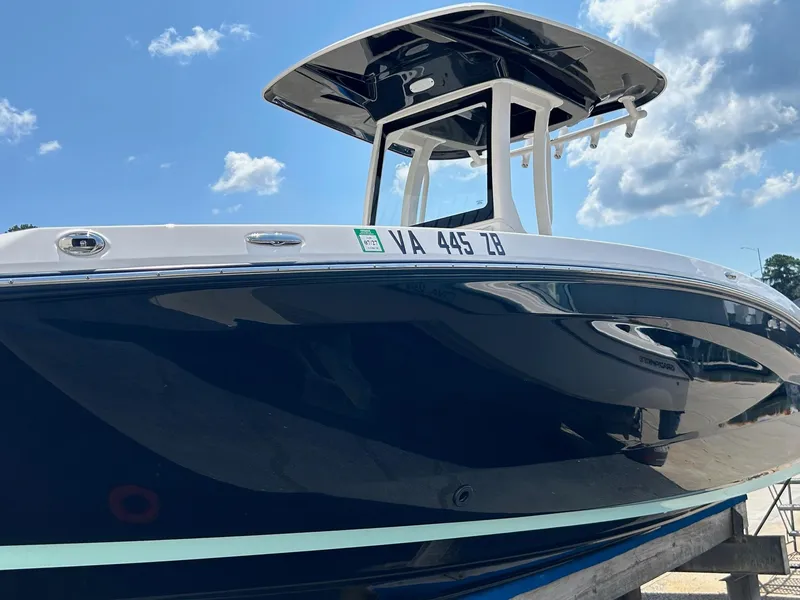 Slide: The Image of 2024 Yamaha Boats 252 FSH Sport, sleek design, blue hull, sunny day. - 1