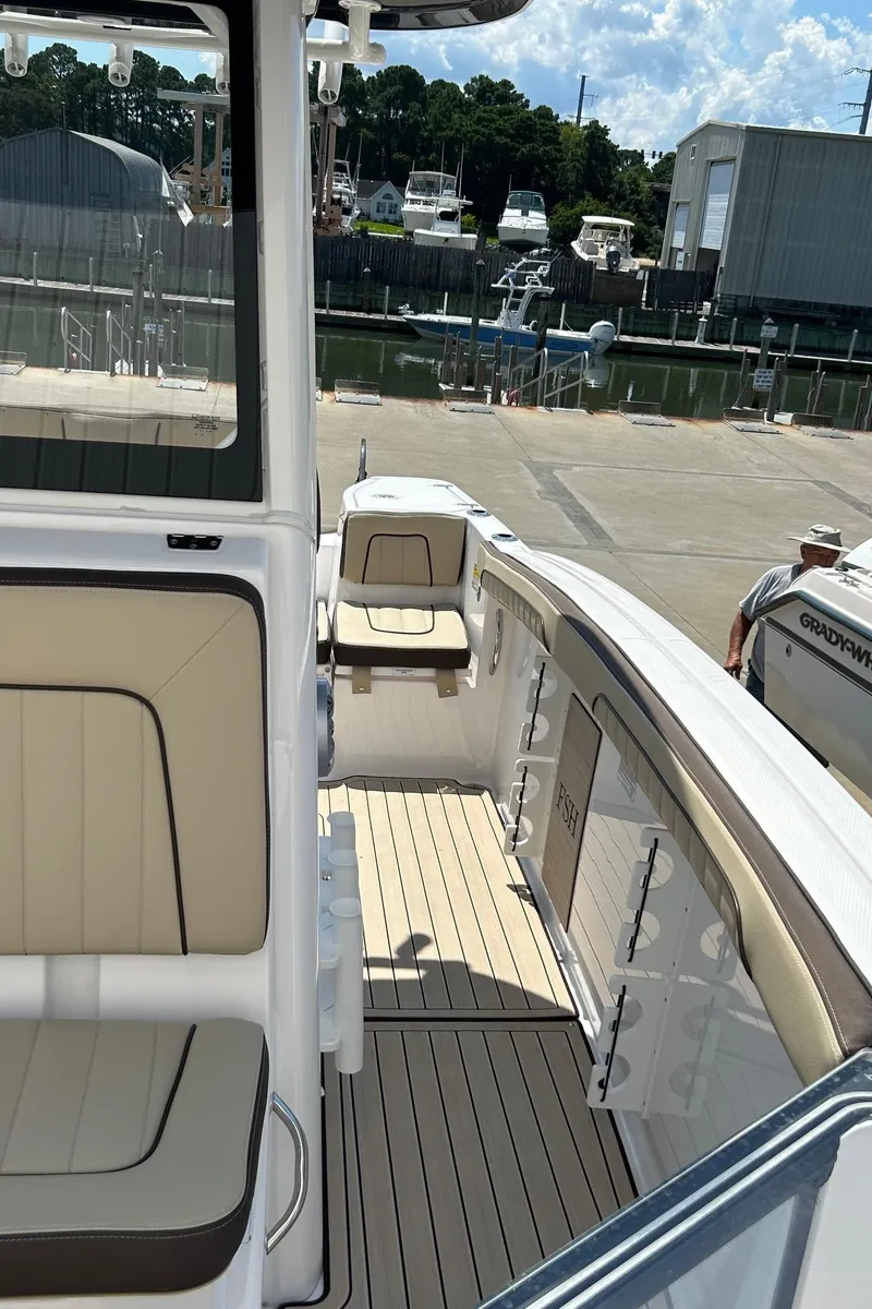 Slide: The Image of 2024 Yamaha Boats 252 FSH Sport interior, featuring sleek seating and modern design at a marina. - 11