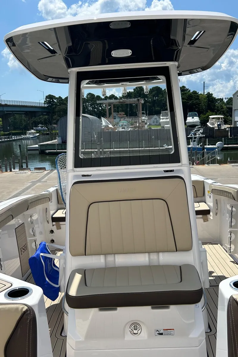 Slide: The Image of 2024 Yamaha Boats 252 FSH Sport at marina, featuring sleek design and spacious seating. - 12