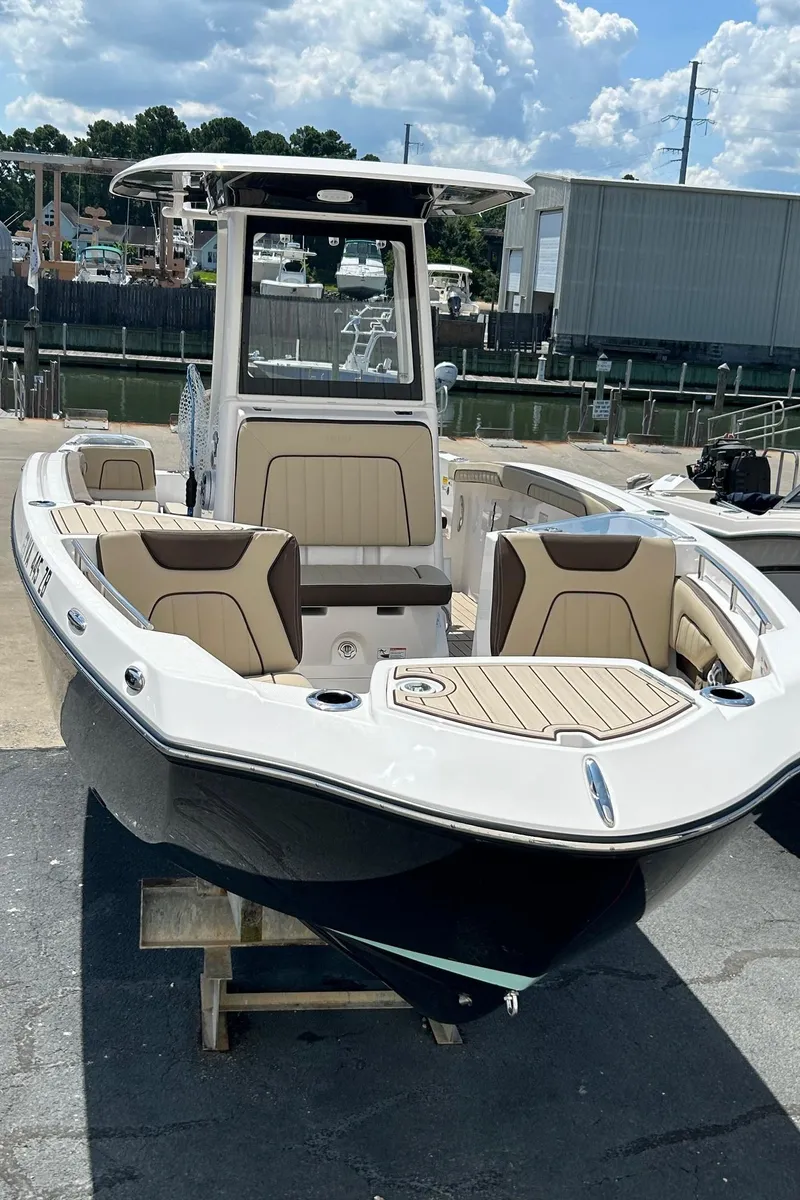 Slide: The Image of 2024 Yamaha Boats 252 FSH Sport, sleek design, docked, sunny day, marina background. - 2