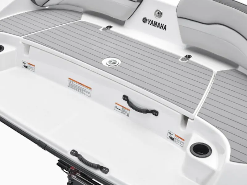 Slide: The Image of 2024 Yamaha AR190 boat swim platform with gray decking and cup holders. - 6