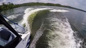 Slide: The Image of 2024 Yamaha AR190 boat creating waves on a scenic lake. - 9
