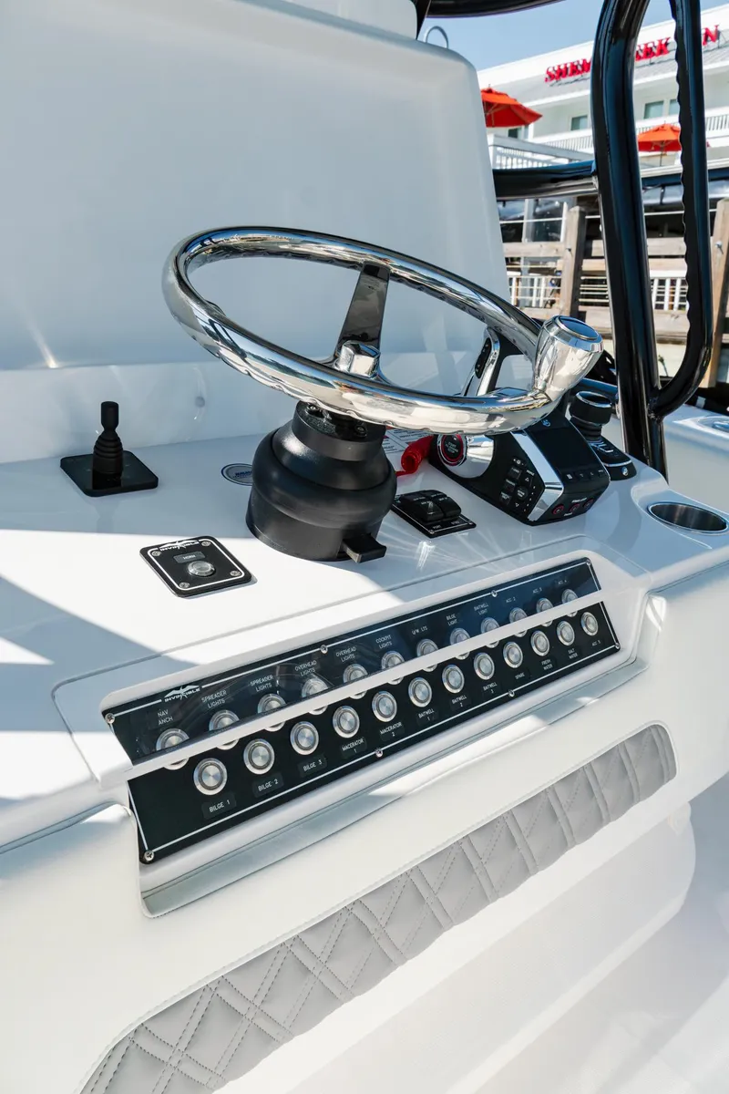Slide: The Image of 2025 Invincible 36 Open Fisherman boat dashboard with steering wheel and controls. - 13