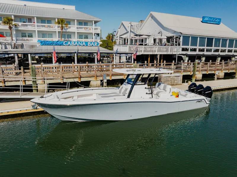 Slide: The Image of 2025 Invincible 36 Open Fisherman boat docked near waterfront bar. - 3