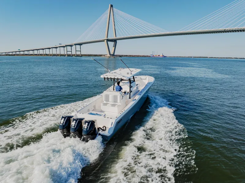 Slide: The Image of 2025 Invincible 36 Open Fisherman boat cruising under a large bridge. - 39