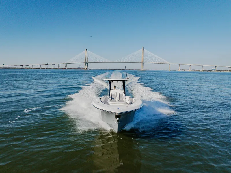 Slide: The Image of 2025 Invincible 36 Open Fisherman boat cruising under a bridge on a sunny day. - 4