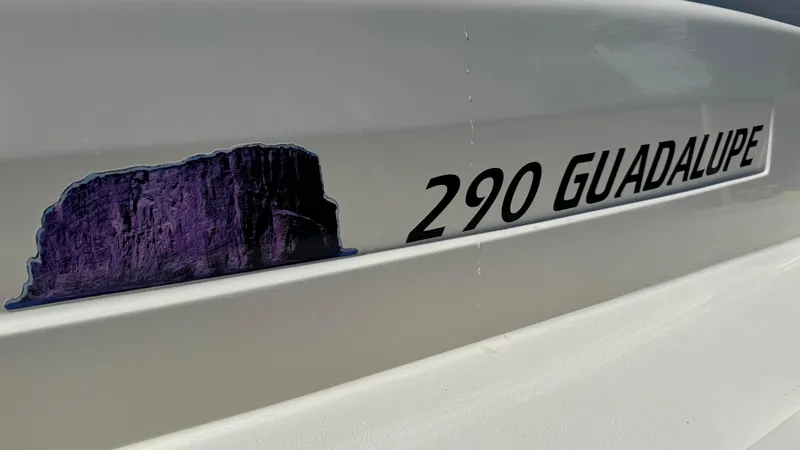 Slide: The Image of 2014 Defiance Guadalupe 290 EX boat with purple rock decal. - 15