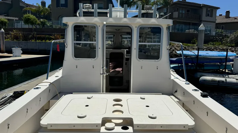 Slide: The Image of 2014 Defiance Guadalupe 290 EX boat docked at marina, rear view of cabin and deck. - 16