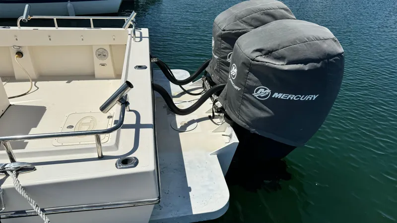 Slide: The Image of 2014 Defiance Guadalupe 290 EX boat with Mercury outboard engines, docked in water. - 7