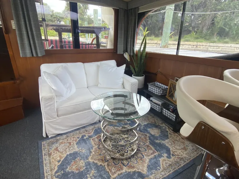 Slide: The Image of Interior of 1986 Midnight Lace 52 Flybridge with white sofa, glass table, and decorative rug. - 11