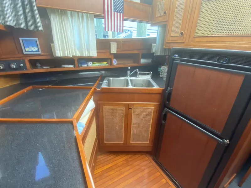 Slide: The Image of 1986 Midnight Lace 52 Flybridge yacht kitchen with wood cabinetry and dual sink. - 17