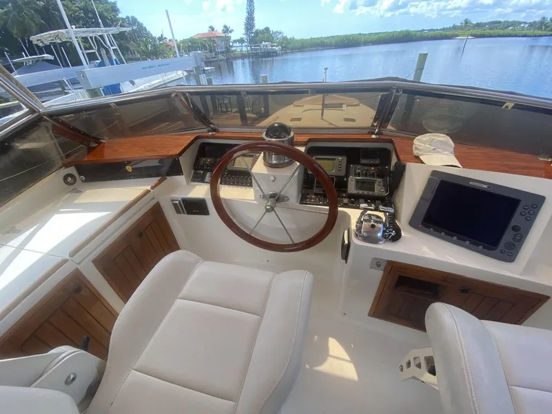 Slide: The Image of 1986 Midnight Lace 52 Flybridge helm with wooden accents and modern navigation equipment. - 22