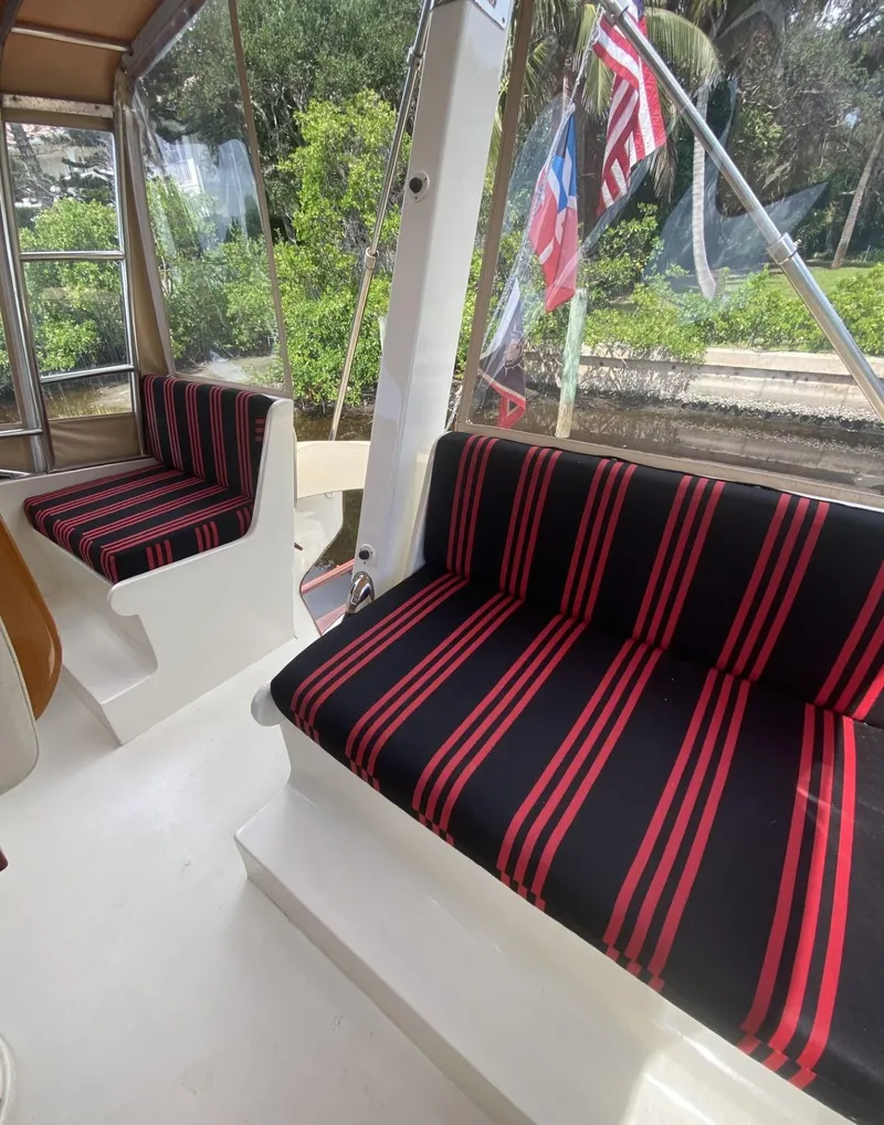 Slide: The Image of 1986 Midnight Lace 52 Flybridge interior with striped seating and outdoor view. - 26