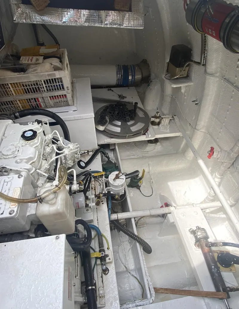 Slide: The Image of Engine room of 1986 Midnight Lace 52 Flybridge yacht, featuring mechanical components and storage. - 31