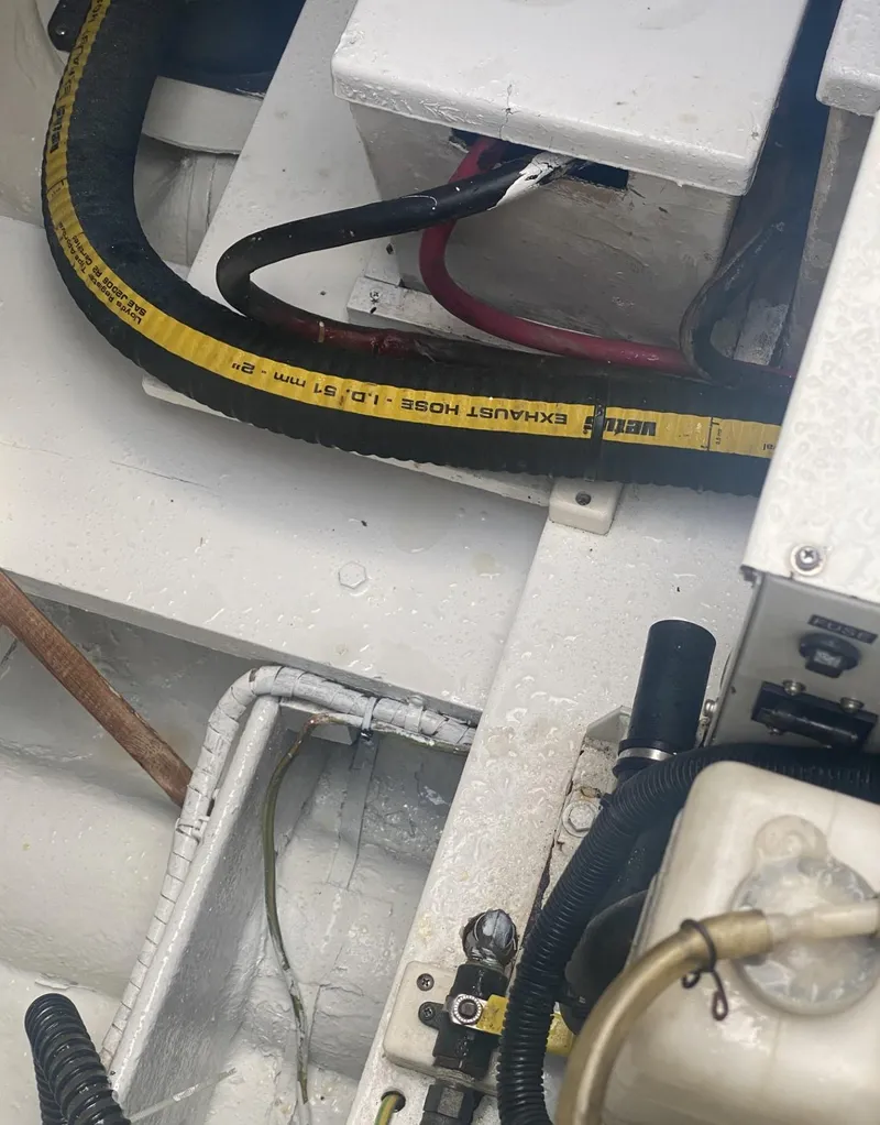 Slide: The Image of Engine compartment of 1986 Midnight Lace 52 Flybridge with visible hoses and wiring. - 32