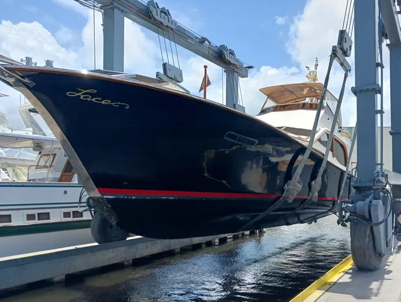 Slide: The Image of 1986 Midnight Lace 52 Flybridge yacht in dry dock, showcasing sleek design and elegant detailing. - 4