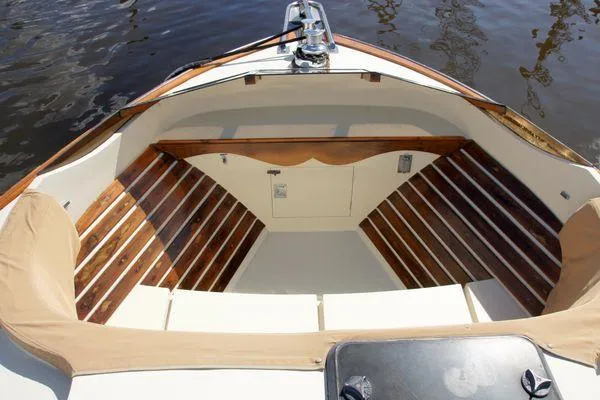 Slide: The Image of 1986 Midnight Lace 52 Flybridge boat with wooden deck and cushioned seating. - 6
