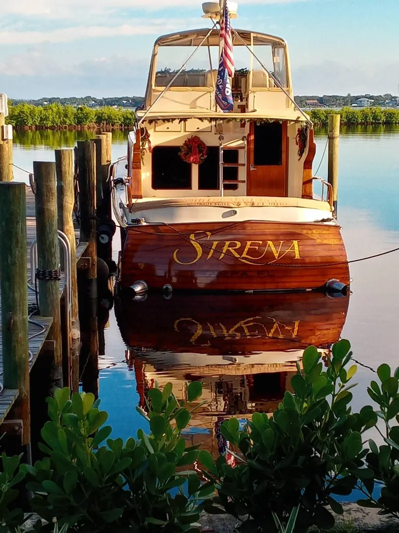 Slide: The Image of 1986 Midnight Lace 52 Flybridge yacht "Sirena" docked, reflecting on calm water. - 8