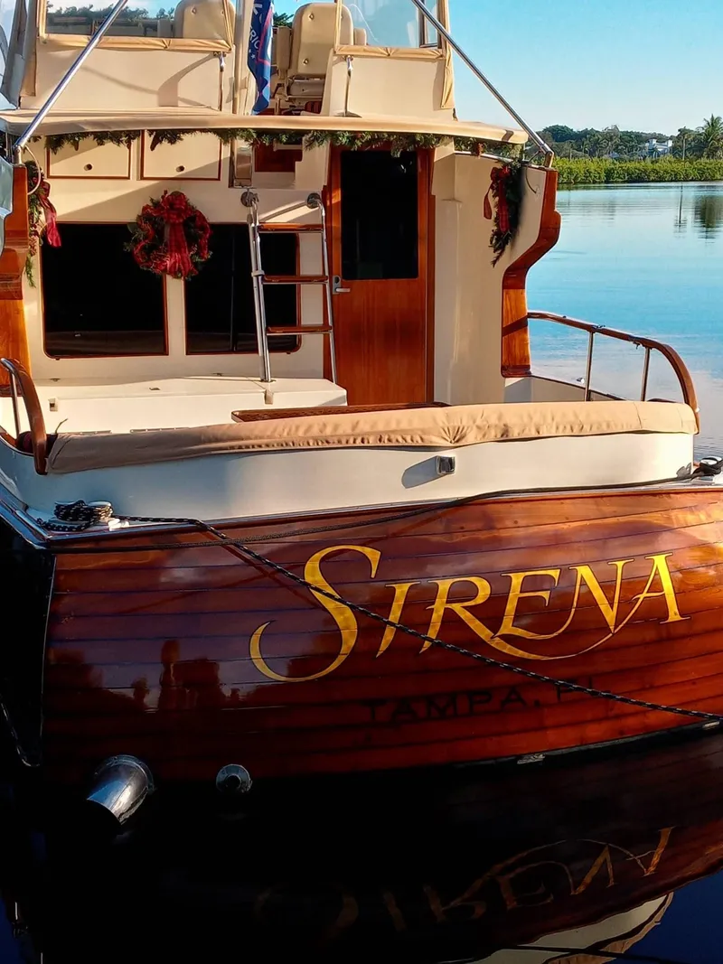 Slide: The Image of 1986 Midnight Lace 52 Flybridge yacht "Sirena" docked on calm water. - 9