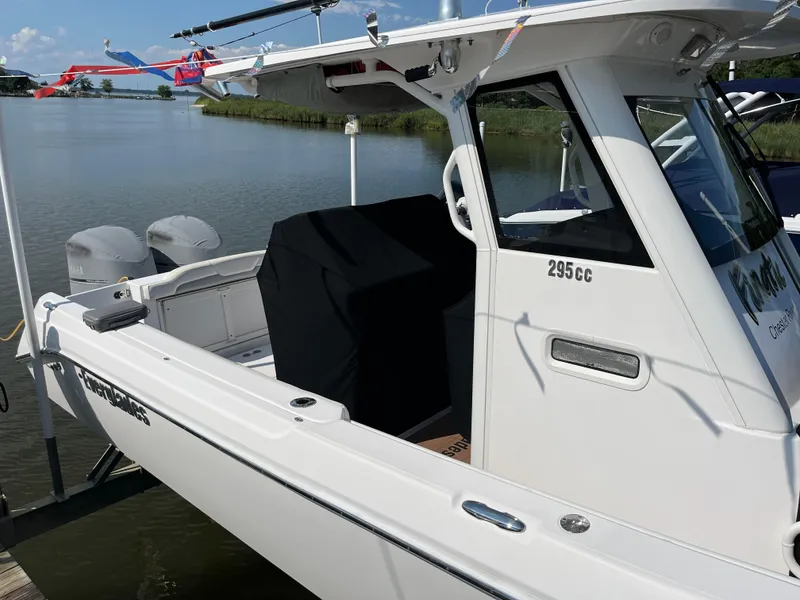 Slide: The Image of 2013 Everglades 295 Center Console boat docked by a serene river. - 10