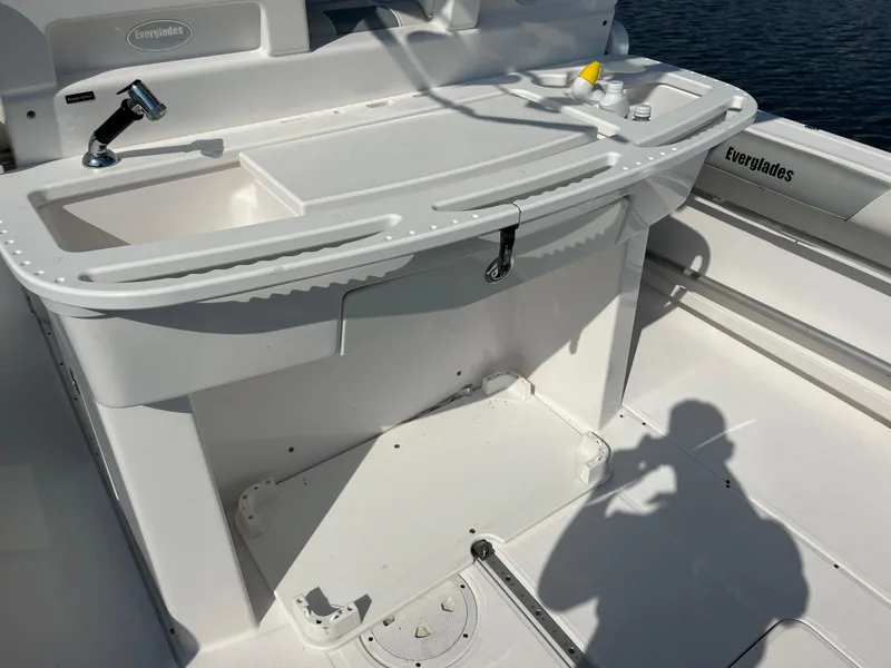 Slide: The Image of 2013 Everglades 295 Center Console boat interior with sink and storage area. - 18