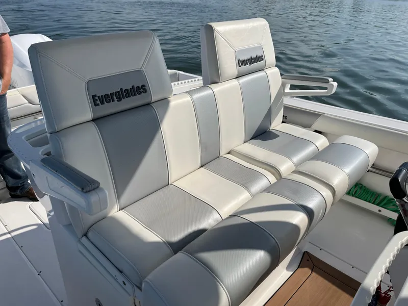 Slide: The Image of 2013 Everglades 295 Center Console boat seating, gray and white upholstery, on calm water. - 22