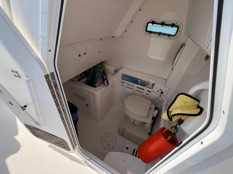 Slide: The Image of Interior of 2013 Everglades 295 Center Console boat with compact bathroom amenities. - 30
