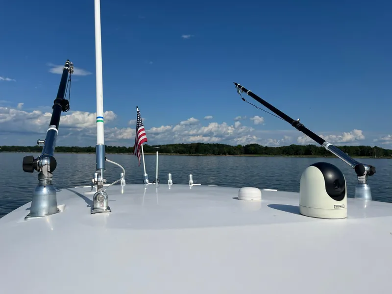 Slide: The Image of 2013 Everglades 295 Center Console boat on calm lake with fishing rods. - 35