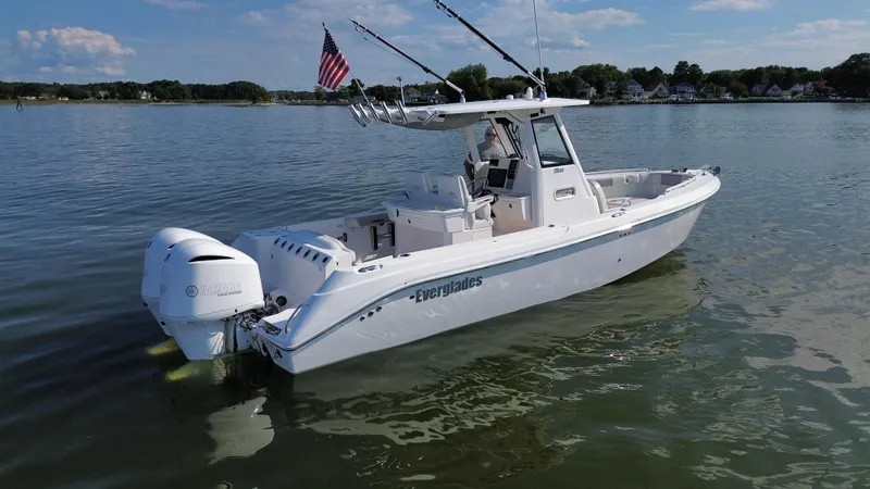 Slide: The Image of 2013 Everglades 295 Center Console boat on calm water with fishing rods. - 5