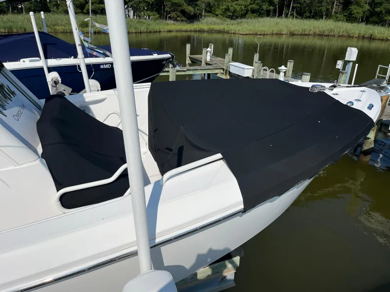 Slide: The Image of 2013 Everglades 295 Center Console boat with black cover docked by the water. - 9