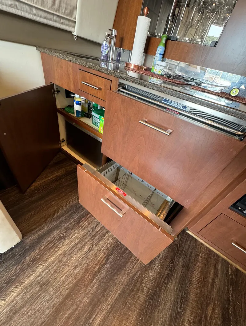 Slide: The Image of 2013 Carver 54 Voyager kitchen with open cabinets and drawers, showcasing storage space. - 13