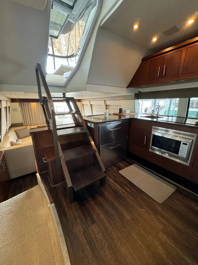Slide: The Image of Interior of 2013 Carver 54 Voyager yacht with modern kitchen and wooden flooring. - 17