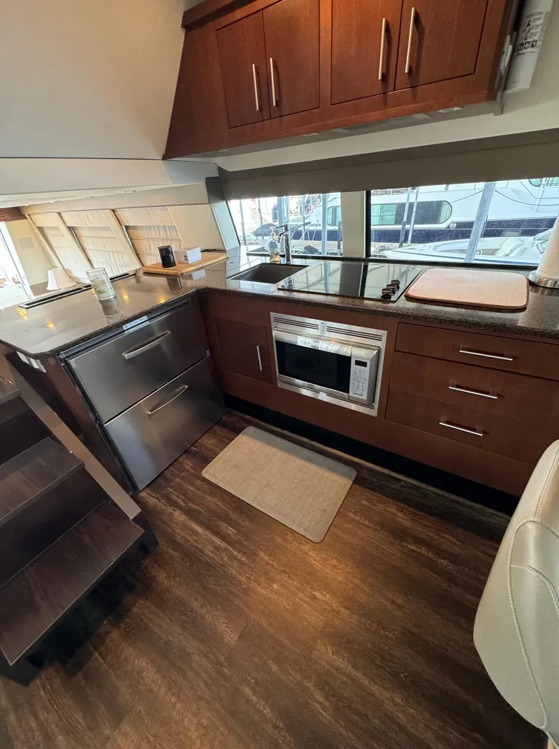 Slide: The Image of 2013 Carver 54 Voyager kitchen with wood cabinets, stainless steel appliances, and large windows. - 23