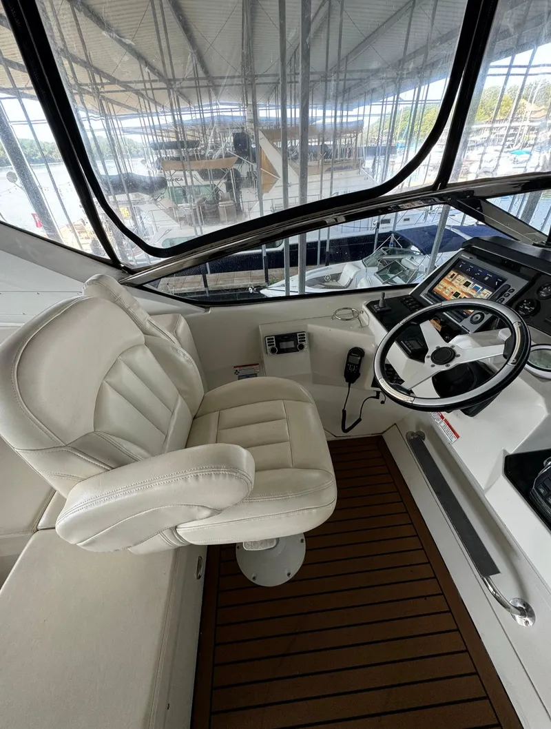 Slide: The Image of Captain's chair and helm of 2013 Carver 54 Voyager yacht, featuring modern controls and wood flooring. - 40
