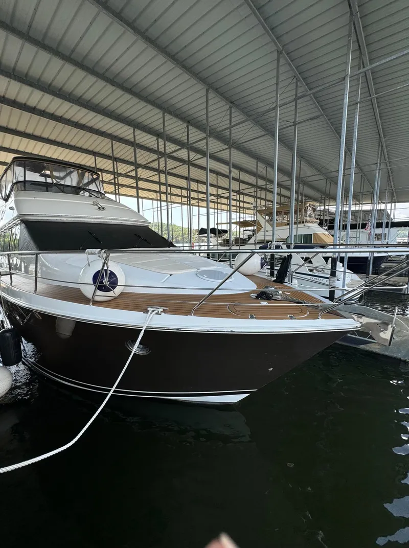 Slide: The Image of 2013 Carver 54 Voyager yacht docked under a covered marina. - 6