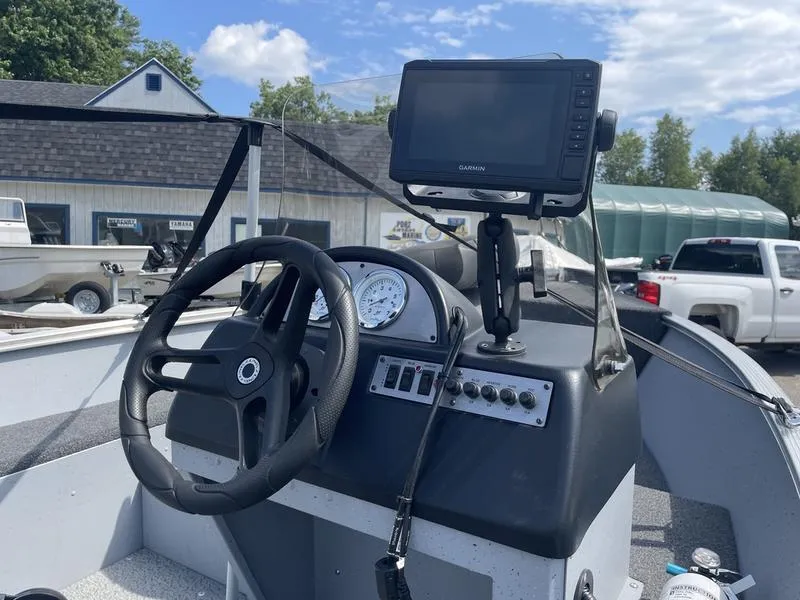 Slide: The Image of 2023 Lund 1600 Fury boat dashboard with steering wheel and navigation system. - 7