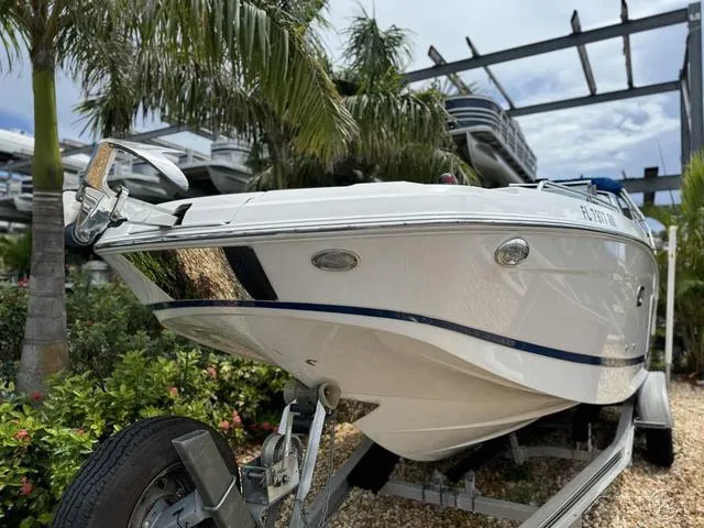 Slide: The Image of 2018 Four Winns HD240 OB boat on trailer, surrounded by tropical plants. - 3
