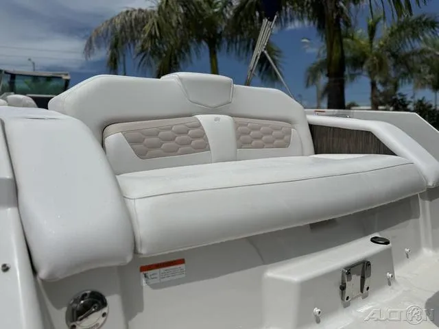 Slide: The Image of 2018 Four Winns HD240 OB boat with white seating, palm trees in background. - 8