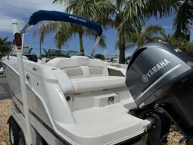 Slide: The Image of 2018 Four Winns HD240 OB boat with Yamaha outboard motor, parked near palm trees. - 9