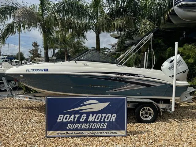 Slide: The Image of 2021 Stingray 201DS boat displayed at Boat & Motor Superstores, surrounded by palm trees. - 1