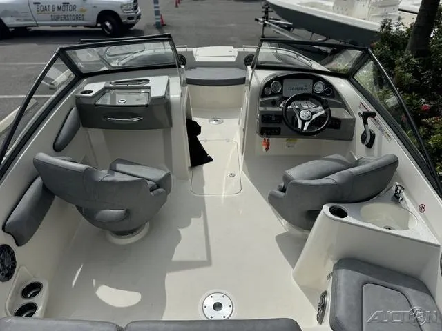Slide: The Image of 2021 Stingray 201DS boat interior with gray seating and modern dashboard. - 12