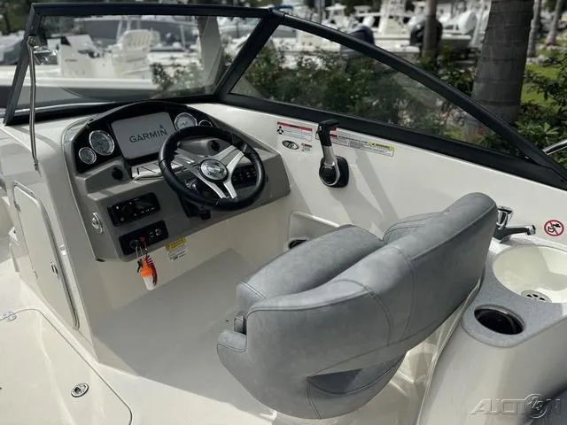 Slide: The Image of 2021 Stingray 201DS boat cockpit with Garmin navigation, steering wheel, and comfortable seating. - 14