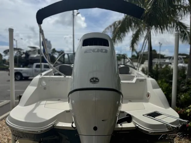 Slide: The Image of 2021 Stingray 201DS boat with powerful outboard motor, parked outdoors. - 6
