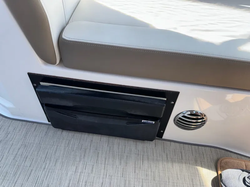 Slide: The Image of 2017 Regal 28 Express interior seating with storage compartment and vent. - 24