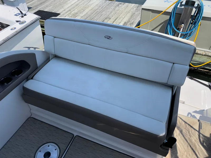 Slide: The Image of 2017 Regal 28 Express boat seating area with white upholstery and cup holders. - 17