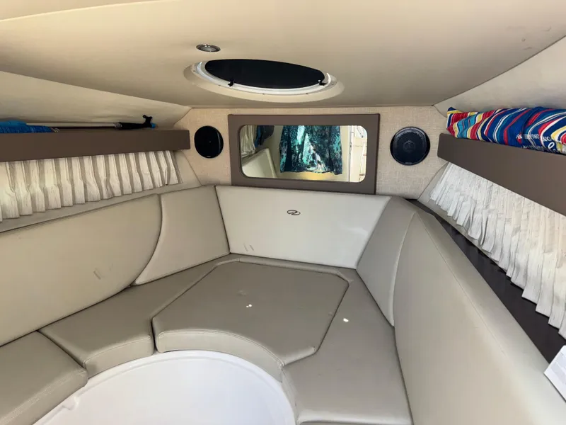 Slide: The Image of 2017 Regal 28 Express cabin interior with beige seating and circular window. - 39